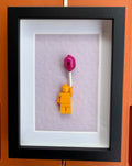 FRAMED YELLOW BRICK FIGURE WITH BALLOON